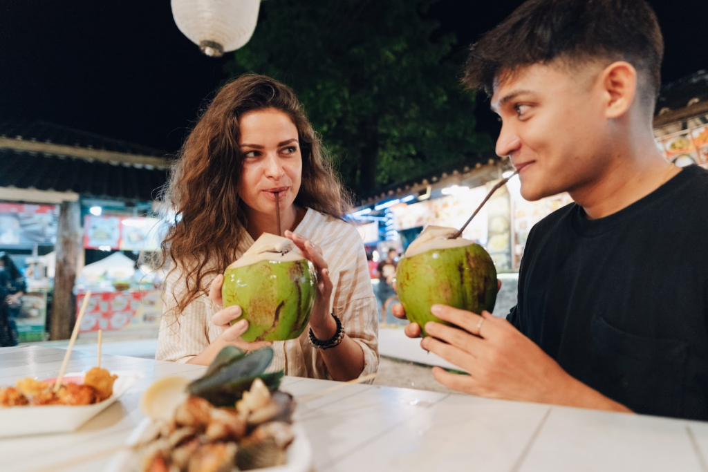 Eat, Move, Make, Fitness, Travel - Tourists drink coconuts in Thailand.