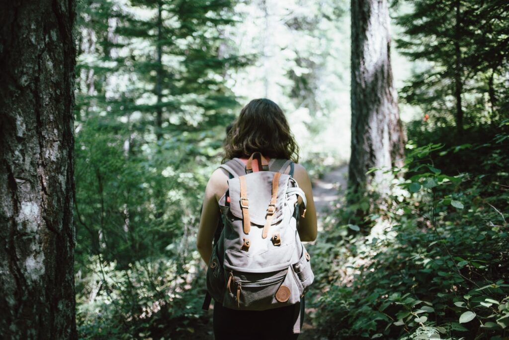 A woman backpacks through the forest